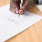 Man signing contract from a deceptive business practice