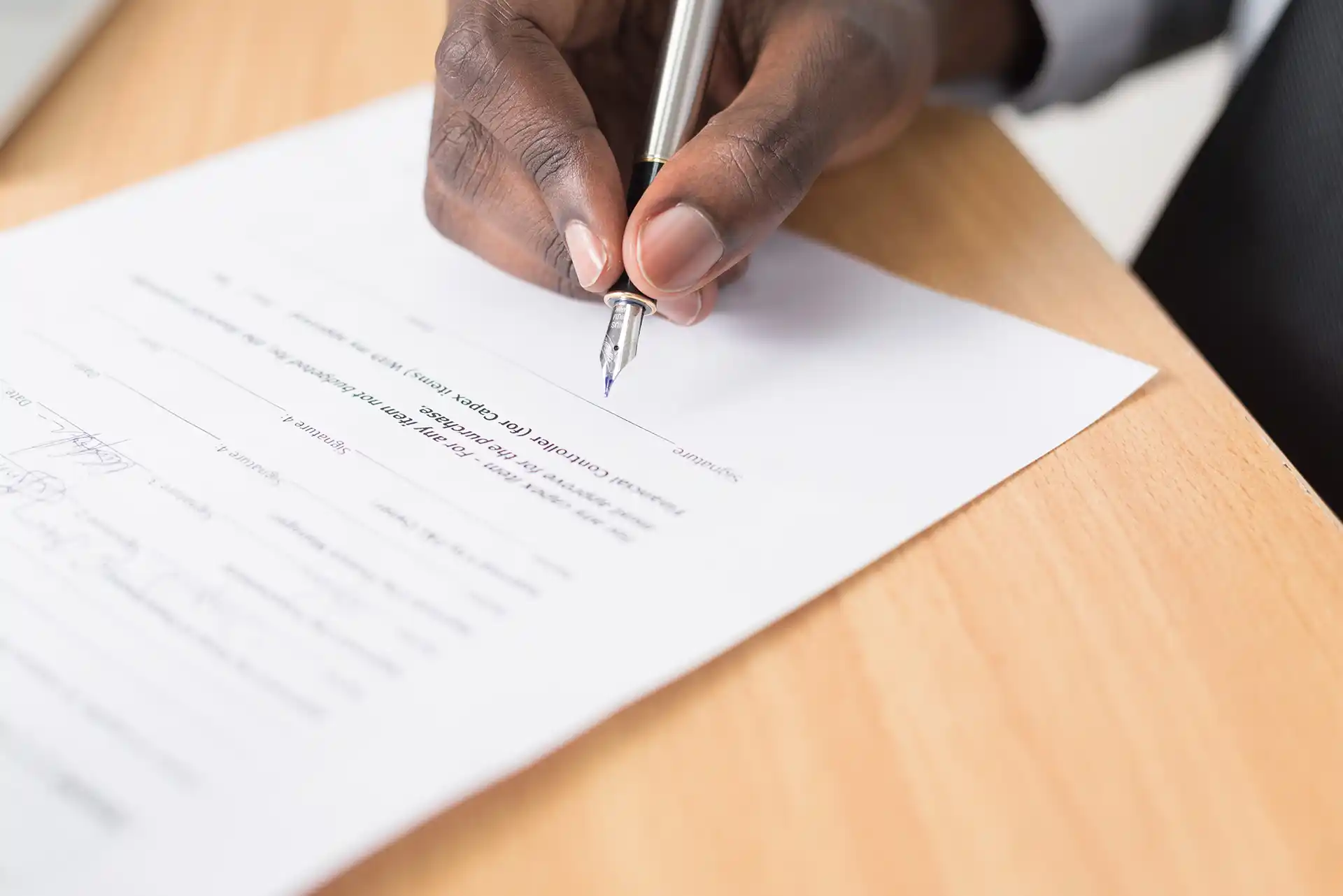 Man signing contract from a deceptive business practice